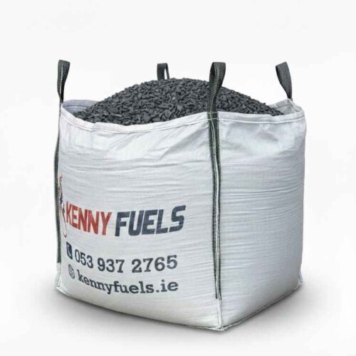 Large white bulk bag filled with black fuel pieces, branded “KENNY FUELS” with contact details printed below. The bag has four lifting loops and sits outdoors, designed for transport and fuel distribution.