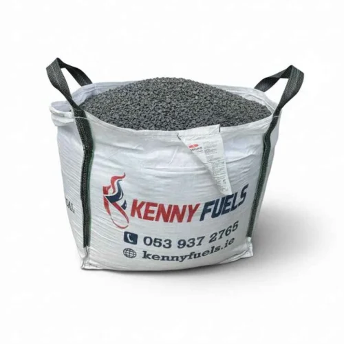 Large white bulk bag filled with dark granular fuel material, branded “KENNY FUELS” with a red and blue flame logo. The bag features black corner lifting straps and printed contact details, with an additional label attached to the front.