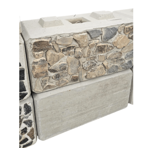 Stacked concrete lego blocks with interlocking design, some featuring decorative stone facades in natural tones of tan, gray, and brown. Ideal for landscaping, retaining walls, and construction projects requiring both structural strength and aesthetic appeal.